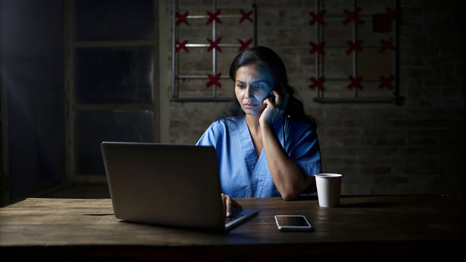 An anxious applicant staring at a laptop with a calendar showing delayed dates