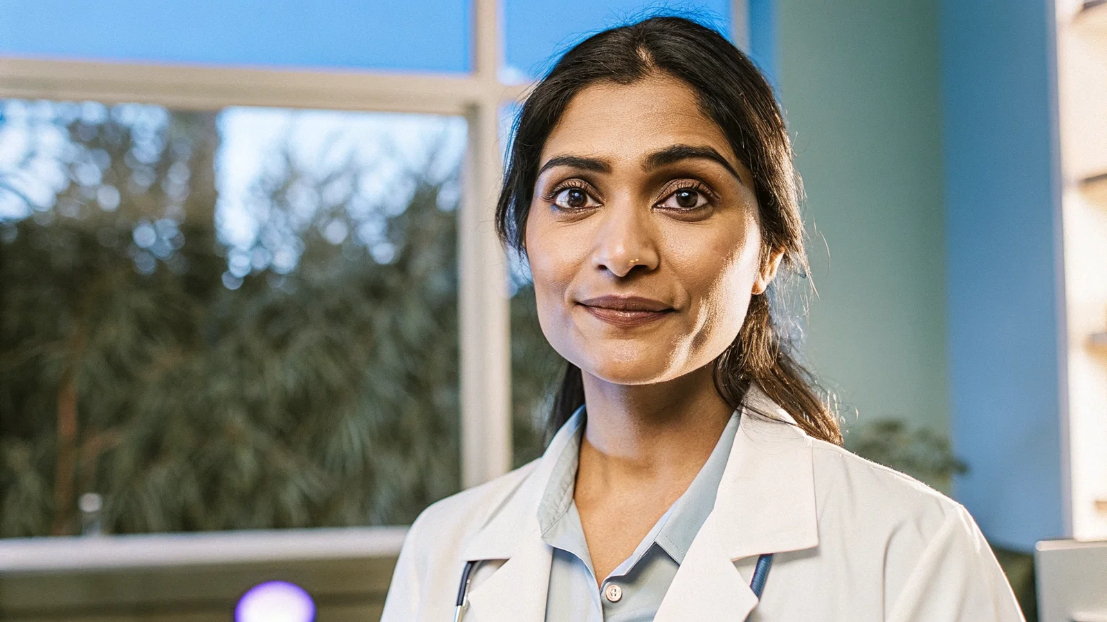 Physician Maintaining Warm Eye Contact While AI Device Rests on Desk